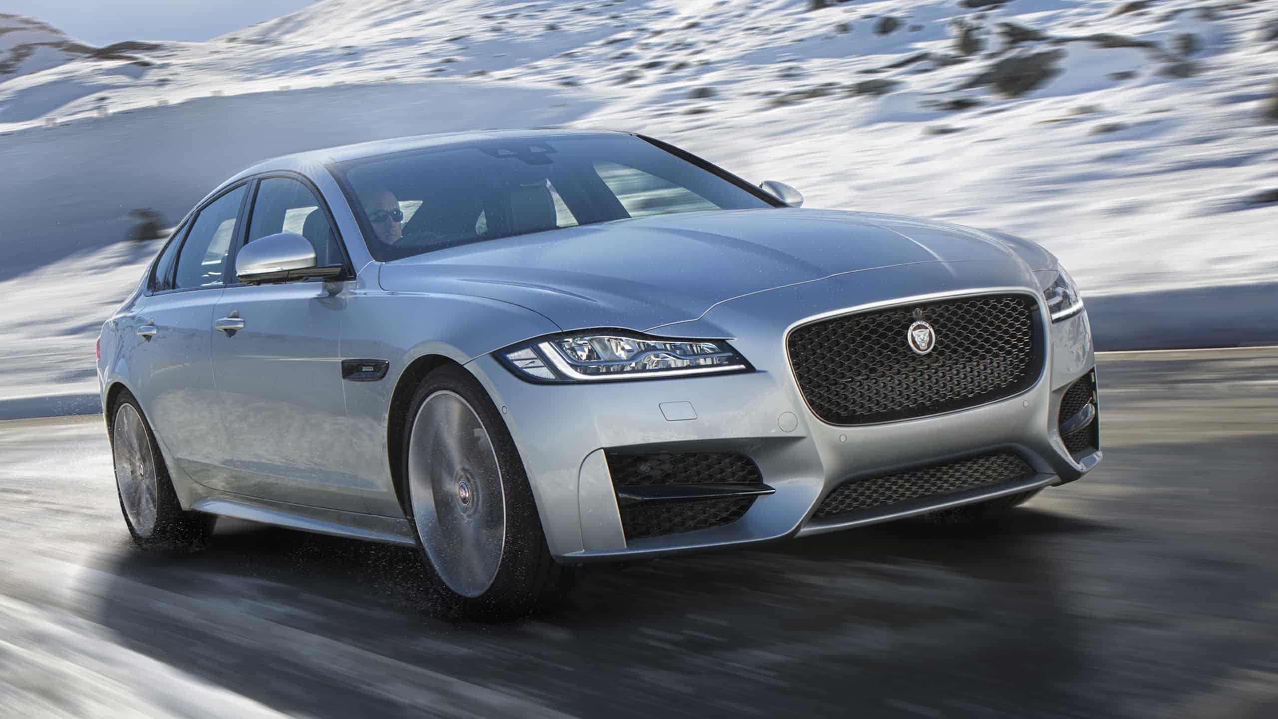 Jaguar XF Moving Upward on Hilly Snow Road